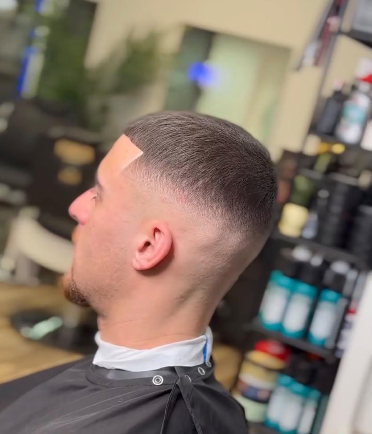 Kortklippt frisyr med skin fade och markerad hårlinje